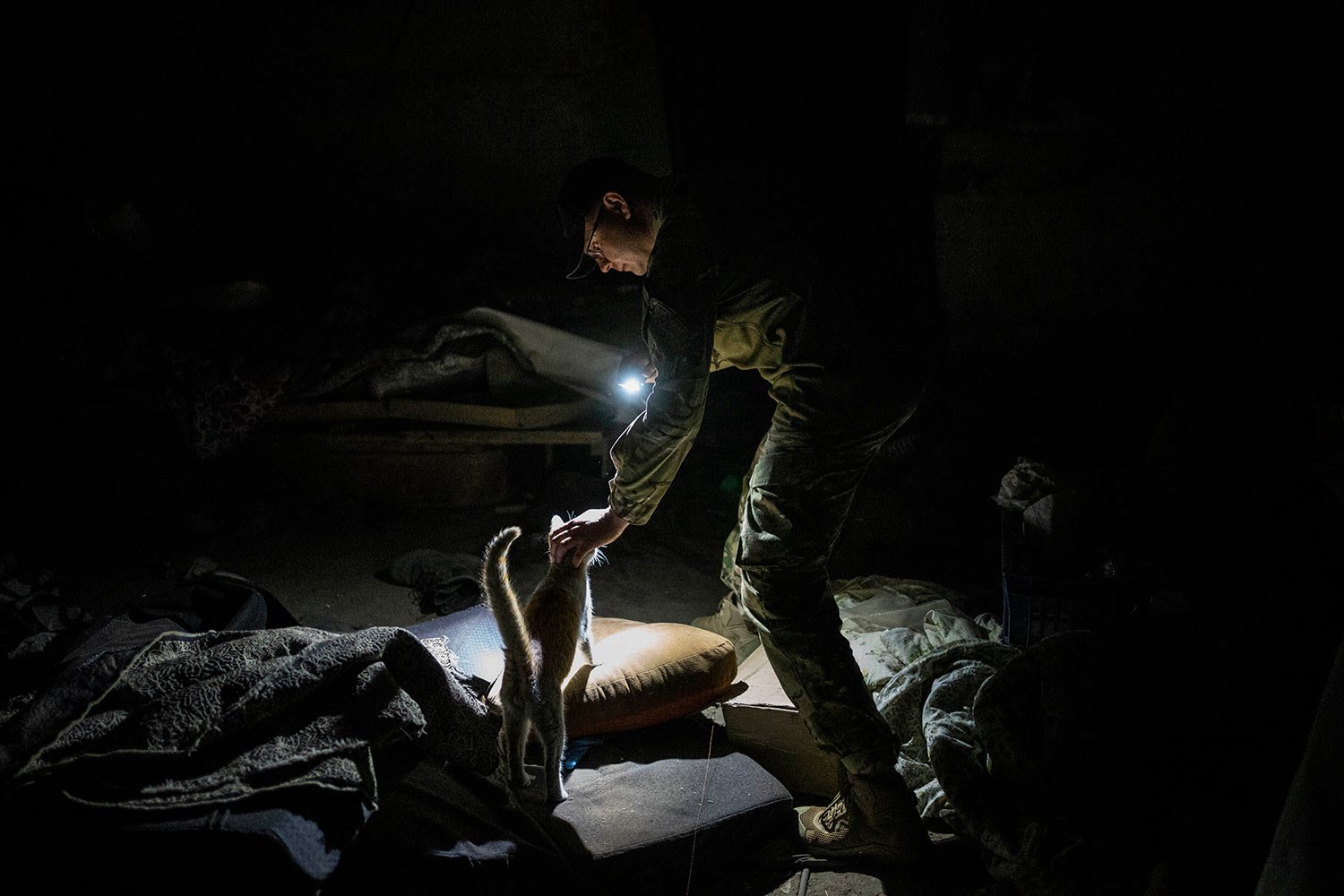  Ukrainian serviceman Anton pets a cat in a basement previously used by Russian soldiers as a temporary base in the village of Malaya Rohan, Kharkiv region, east Ukraine, Monday, May 16, 2022. (AP Photo/Bernat Armangue) 