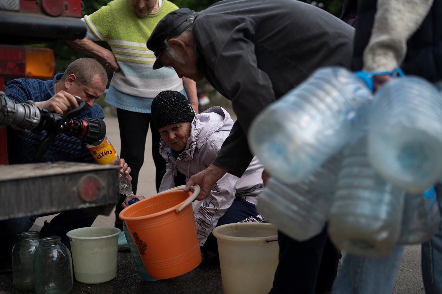  People gather to fill cans with water from a firefighters truck in Lysychansk, Luhansk region, Ukraine, Friday, May 13, 2022. (AP Photo/Leo Correa) 