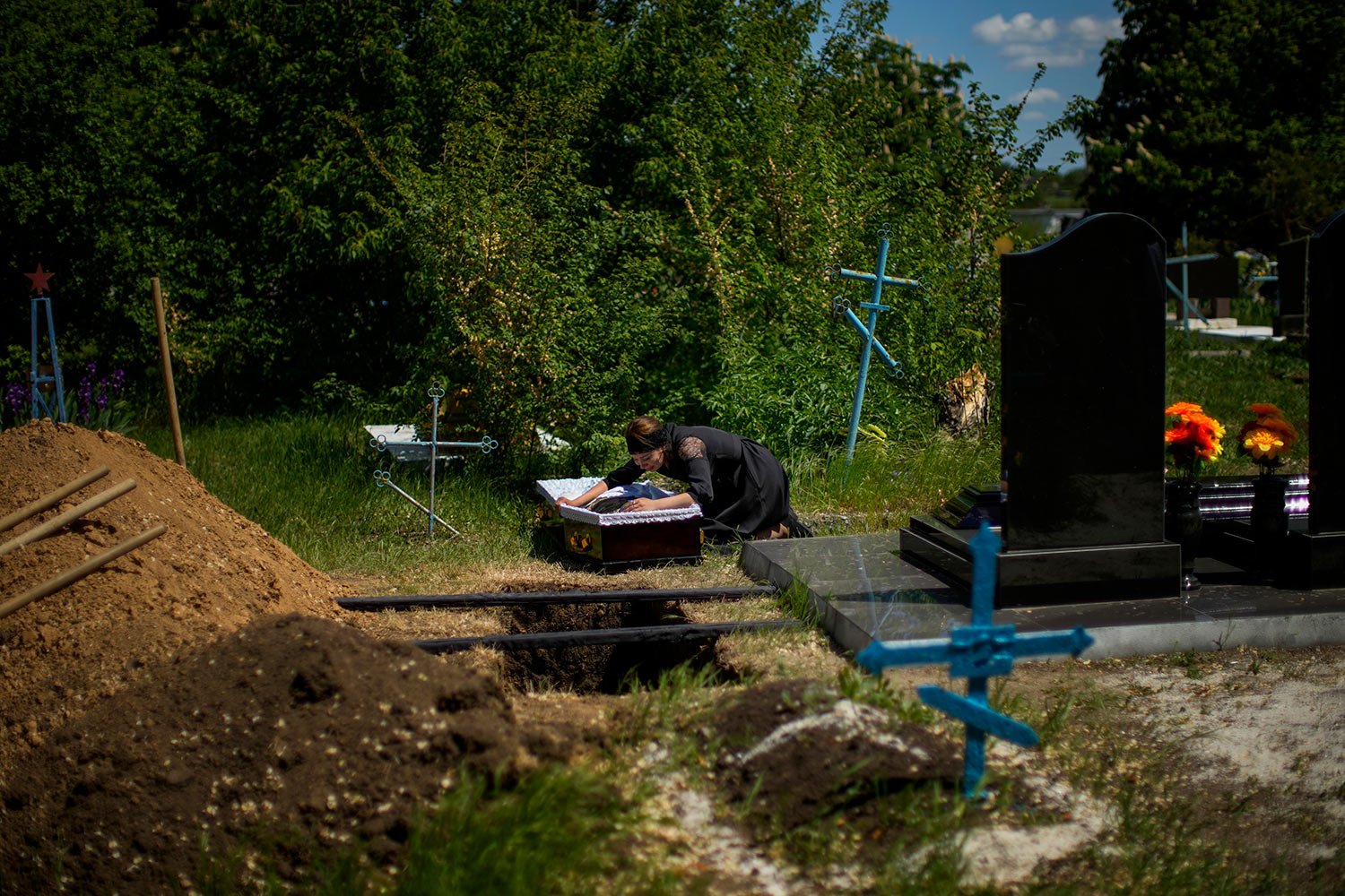  Iuliia Loseva cries over the coffin of her husband Volodymyr Losev, 38, during his funeral at a cemetery in Zorya Truda, Odesa region, Ukraine, Monday, May 16, 2022. Volodymyr Losev, a Ukrainian volunteer soldier, was killed on May 7 when the milita