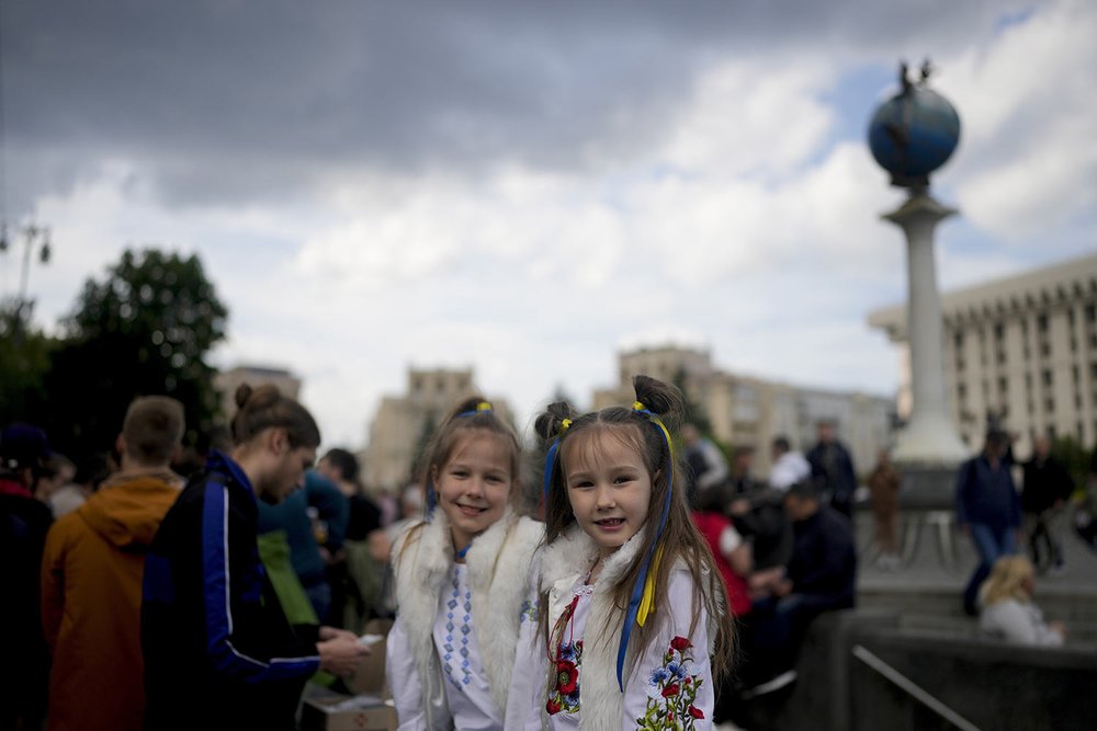  Girls smile at the camera in downtown Kyiv, Ukraine, Monday, May 23, 2022, amid the 3-month-old Russian invasion. Even in regions out of the range of the heavy guns, frequent air raid sirens wail as a constant reminder that a Russian missile can str