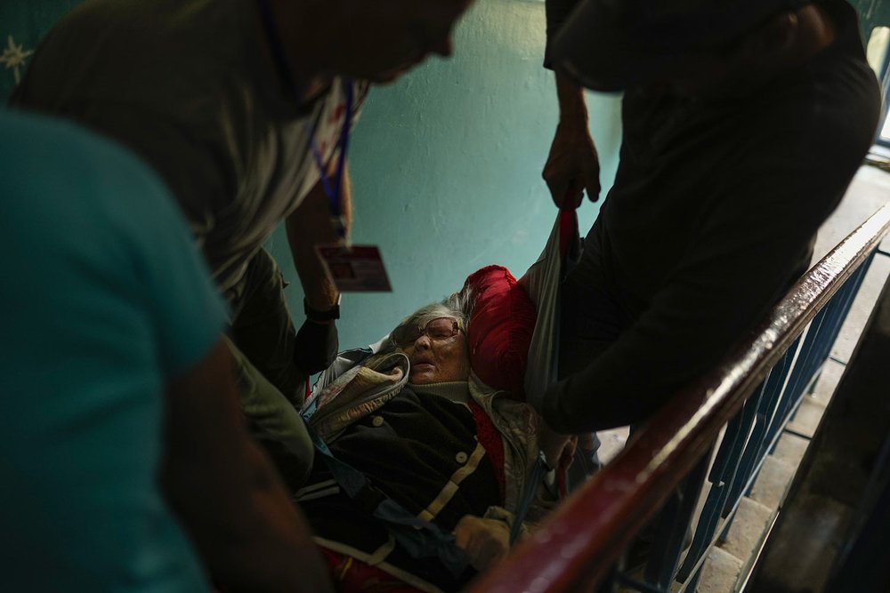  A woman is evacuated from her home by volunteers from the Vostok SOS charitable organization in Kramatorsk, eastern Ukraine, Thursday, May 26, 2022, as fighting rages in eastern Ukraine. (AP Photo/Francisco Seco) 