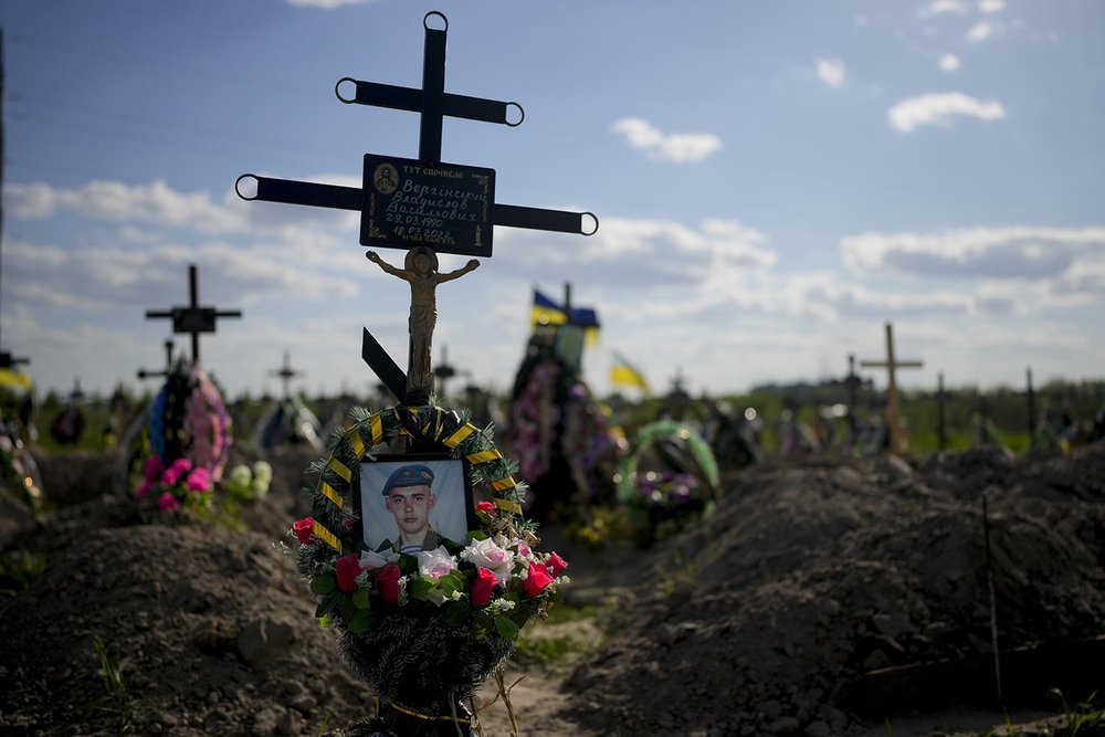  The photo of a Ukrainian soldier who died during Russia's invasion decorates his tomb at Bucha cemetery on the outskirts of Kyiv, Ukraine, Tuesday, May 24, 2022. (AP Photo/Natacha Pisarenko) 
