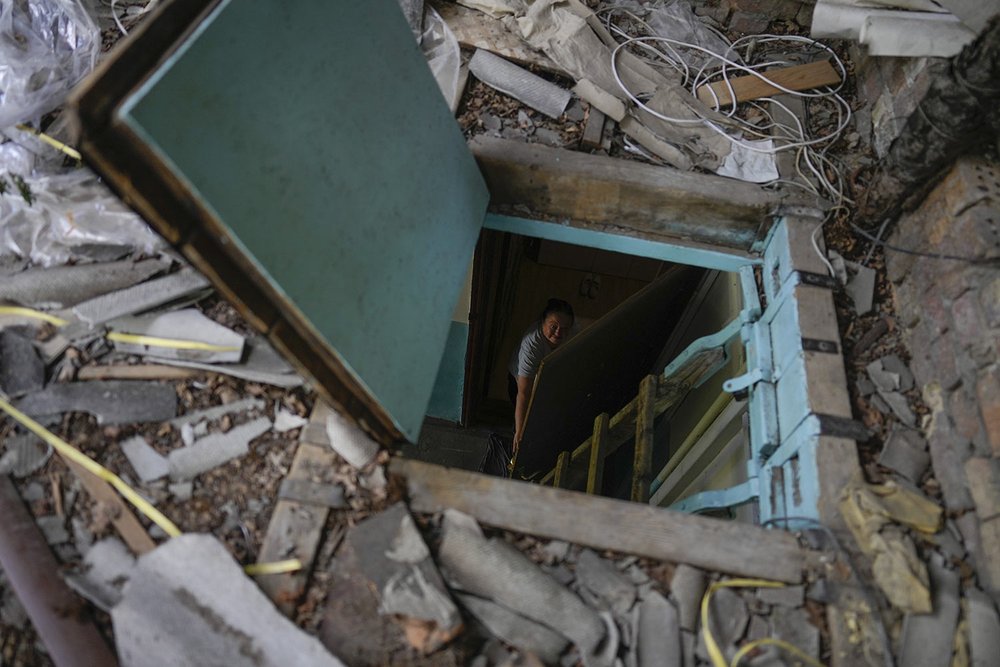  Liudmyla Voronina opens a skylight window on the roof of her home damaged by attacks in Irpin on the outskirts of Kyiv, Ukraine, Thursday, May 26, 2022. Voronina now lives alone here, fearing new attacks or that the roof will fall, after her son and