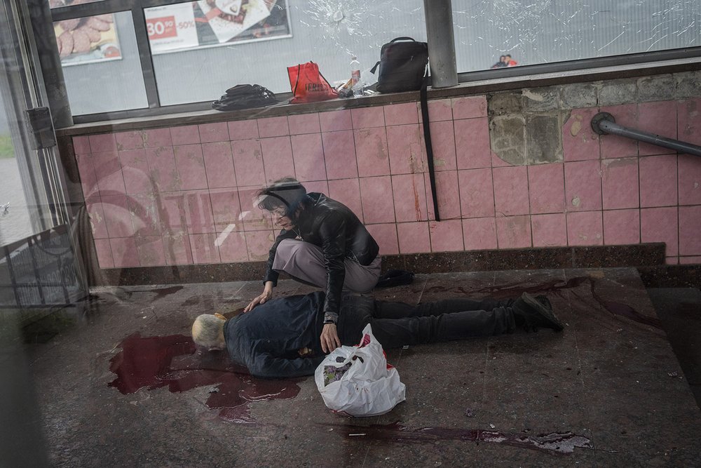  Elena kneels over the body of her husband Alexey after he died during shelling at the subway in Kharkiv in eastern Ukraine, Thursday, May 26, 2022. (AP Photo/Bernat Armangue) 