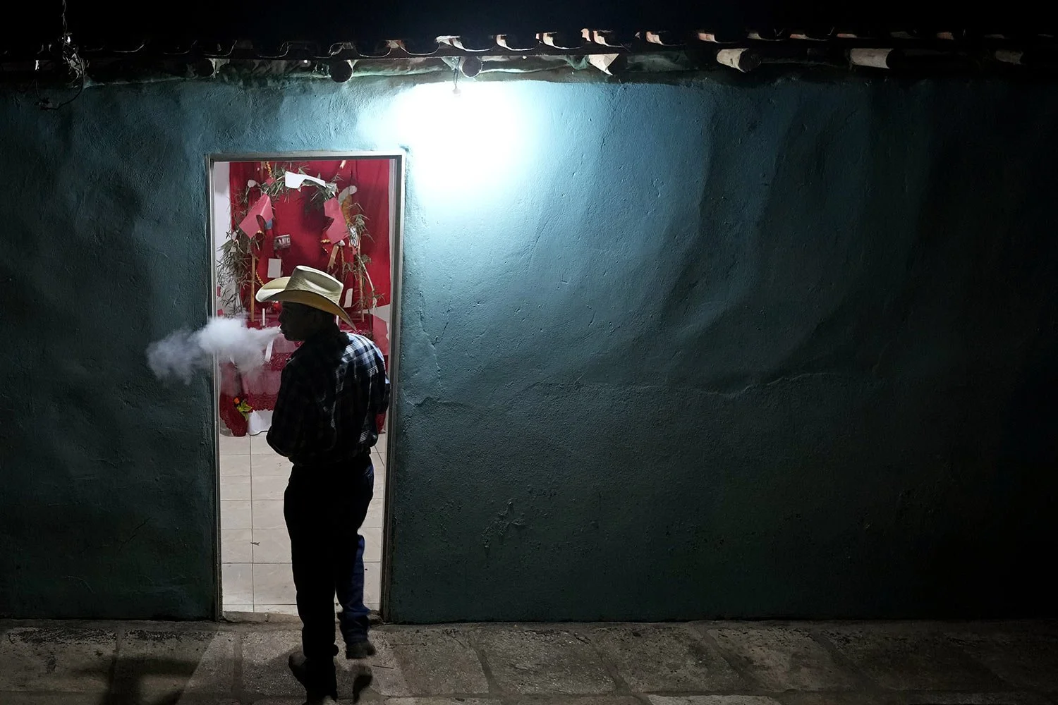  A reveler smokes outside the main altar set up for the Feast of the Divine, in Pirenopolis, Goias state, Brazil, May 29, 2022. (AP Photo/Eraldo Peres) 