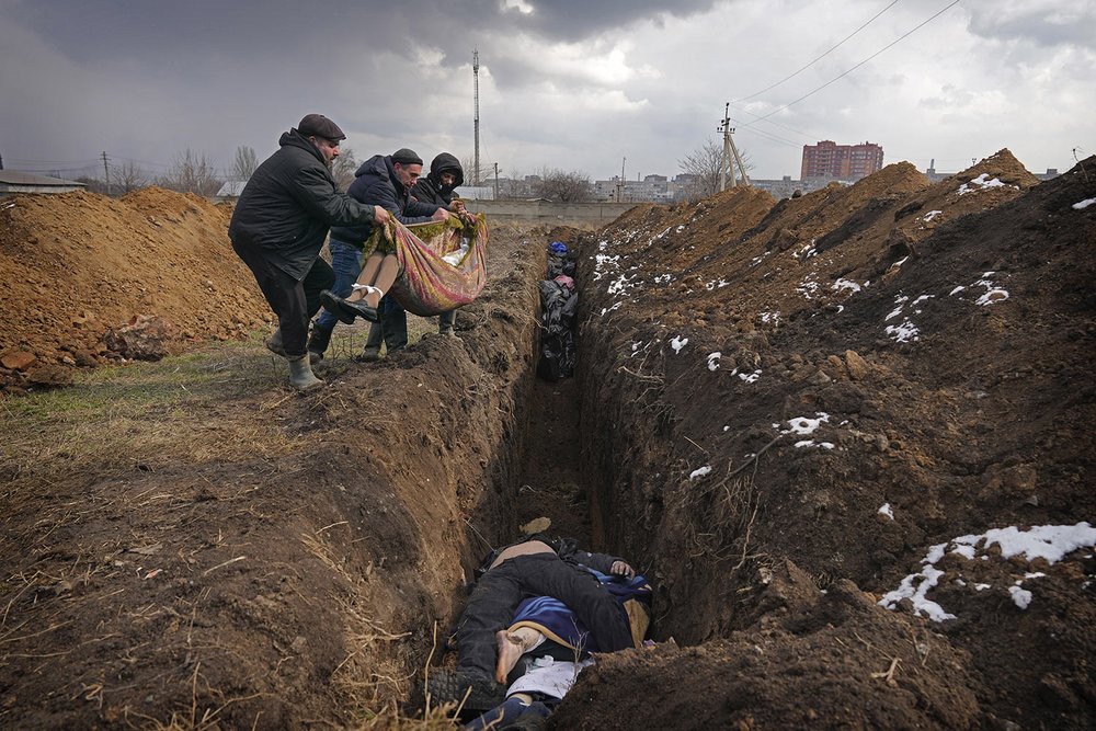  Bodies are placed into a mass grave on the outskirts of Mariupol, Ukraine, Wednesday, March 9, 2022. (AP Photo/Evgeniy Maloletka) 