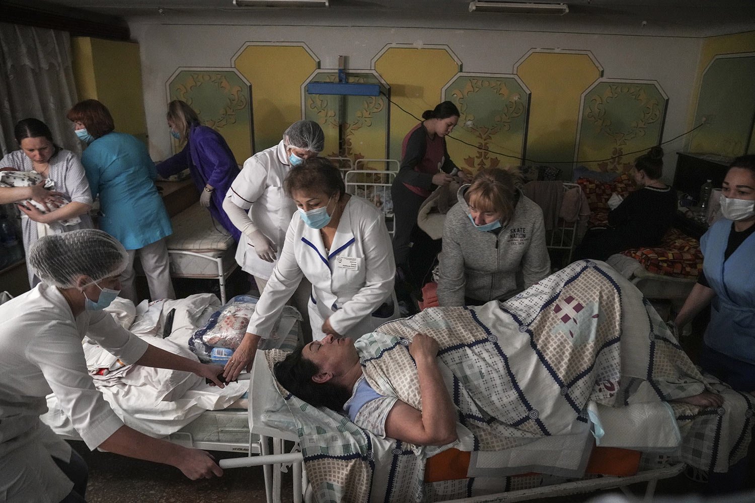  Medical workers move a patient in the basement of a maternity hospital that has been converted into a medical ward and bomb shelter in Mariupol, Ukraine, Tuesday, March 1, 2022. (AP Photo/Evgeniy Maloletka) 
