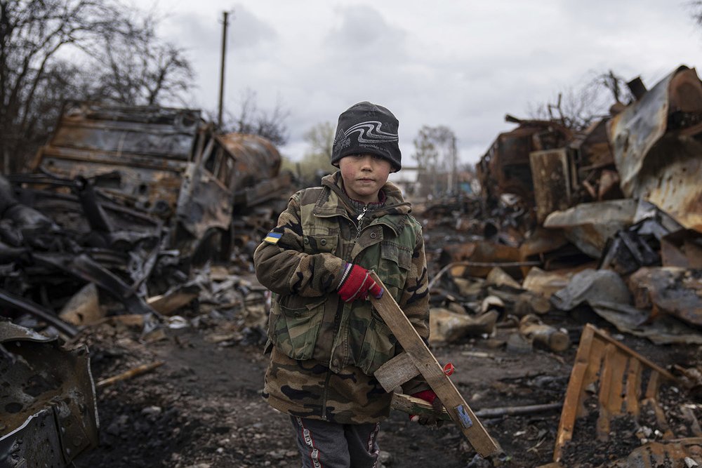  Yehor, 7, holds a toy rifle next to destroyed Russian military vehicles near Chernihiv, Ukraine, Sunday, April 17, 2022. (AP Photo/Evgeniy Maloletka) 