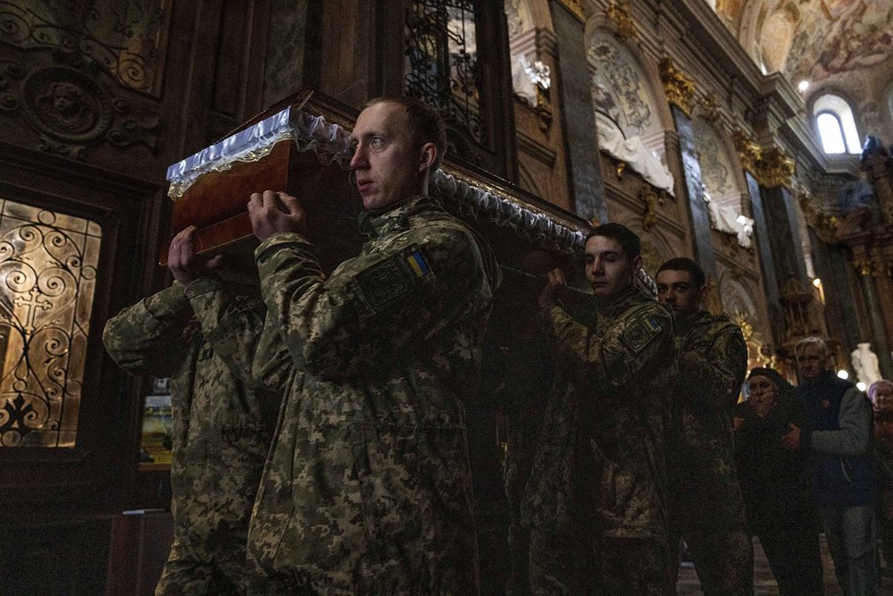  The mother of 40-year-old Senior Lieutenant Oliynyk Dmytro, who was killed in combat, mourns his death as she walks behind his coffin during his funeral outside the Holy Apostles Peter and Paul Church in Lviv, western Ukraine, Saturday, April 2, 202