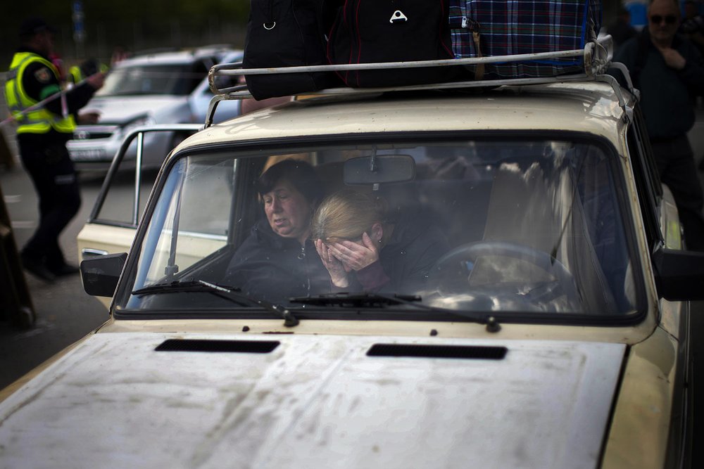  People wait in a car to be processed at a reception center for displaced people in Zaporizhzhia, Ukraine, Monday, May 2, 2022. (AP Photo/Francisco Seco) 