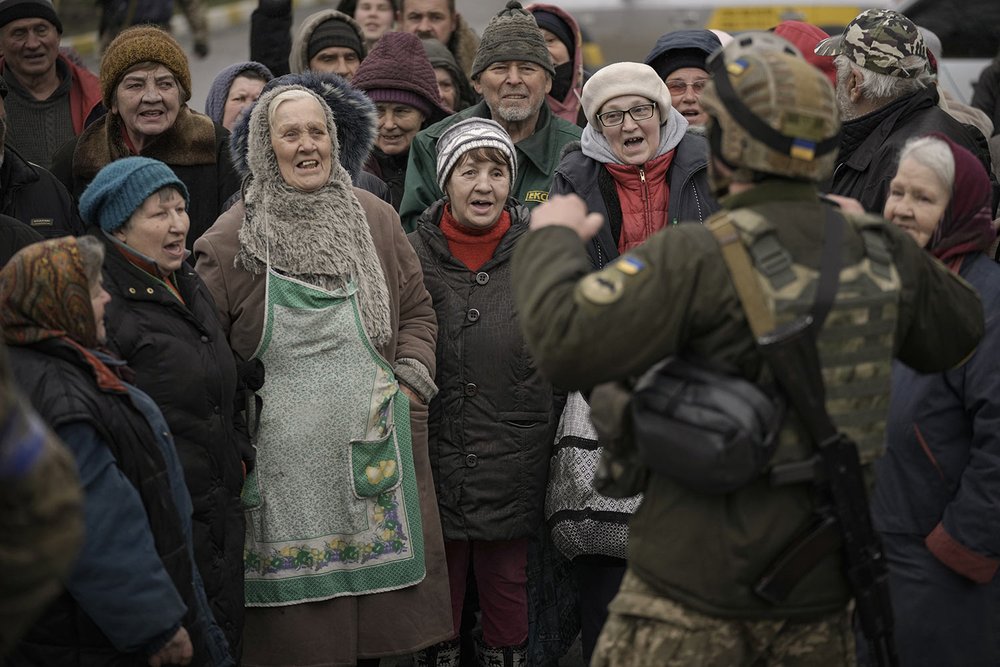  Civilians cheer along with a Ukrainian serviceman as a convoy of military and aid vehicles arrive at the formerly Russian-occupied Kyiv suburb of Bucha, Ukraine, Saturday, April 2, 2022.(AP Photo/Vadim Ghirda) 