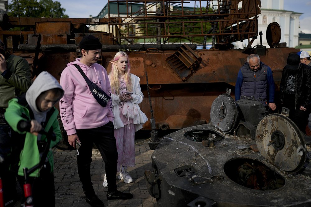  People look at a destroyed Russian tank placed at Mykhailivs'ka Square in downtown Kyiv, Ukraine, Monday, May 23, 2022. (AP Photo/Natacha Pisarenko) 