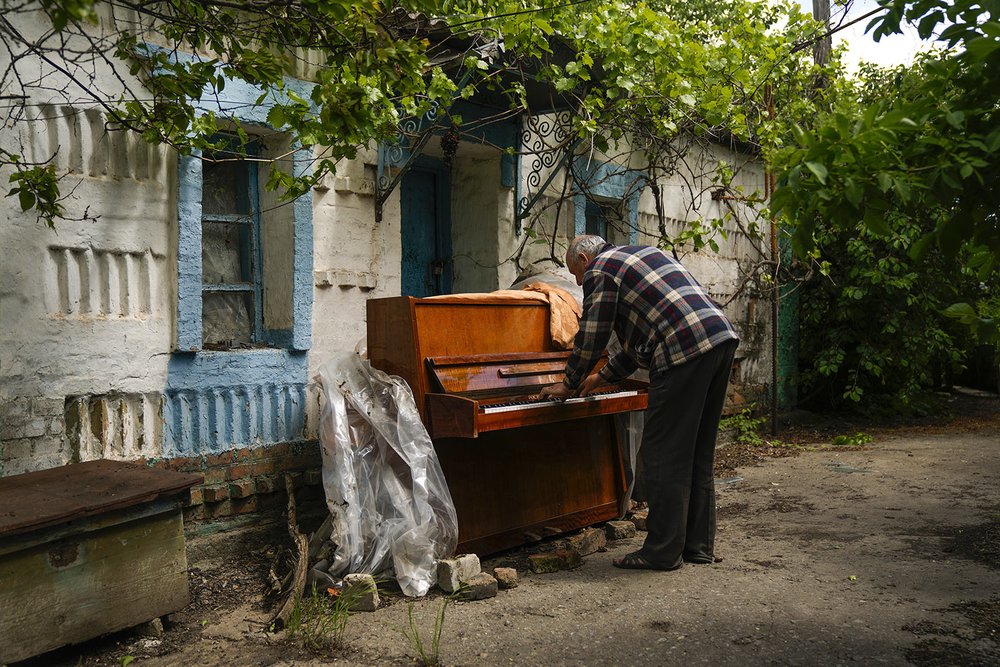  Anatolii Virko plays a piano outside a house likely damaged after a Russian bombing in Velyka Kostromka village, Ukraine, Thursday, May 19, 2022. (AP Photo/Francisco Seco) 
