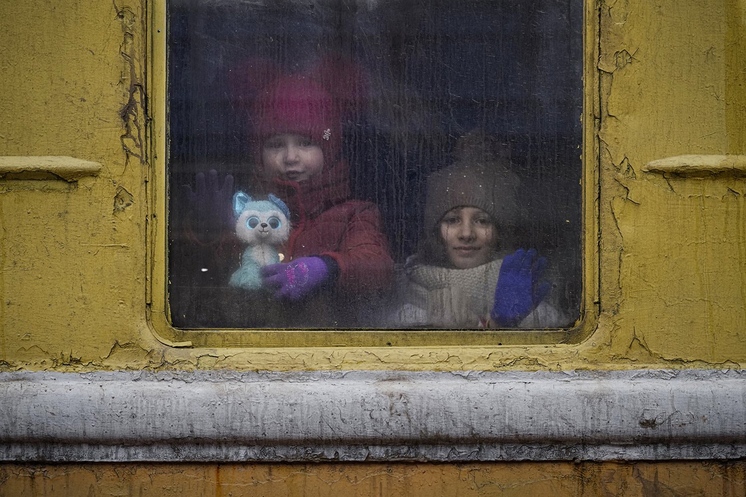  Children look out the window of an unheated Lviv-bound train, in Kyiv, Ukraine, Thursday, March 3, 2022. (AP Photo/Vadim Ghirda) 