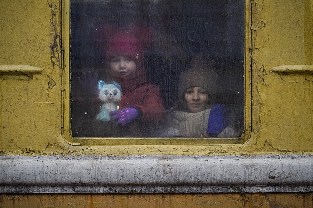  Children look out the window of an unheated Lviv-bound train, in Kyiv, Ukraine, Thursday, March 3, 2022. (AP Photo/Vadim Ghirda) 