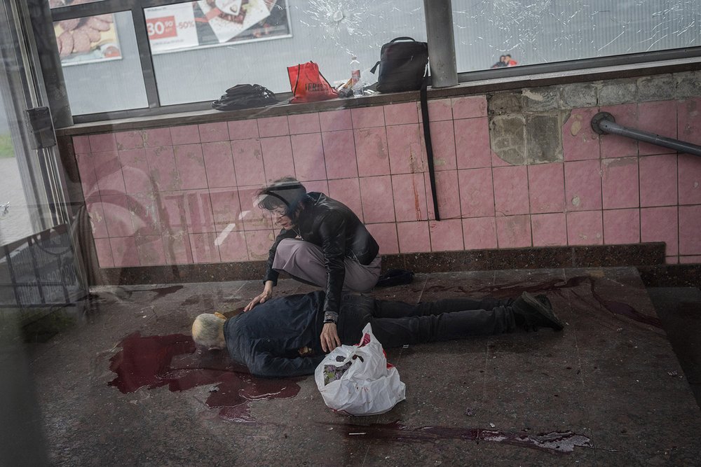 Elena kneels down next to the body of her dead husband Alexey, who died during shelling at the subway in Kharkiv, eastern Ukraine, Thursday, May 26, 2022. (AP Photo/Bernat Armangue) 