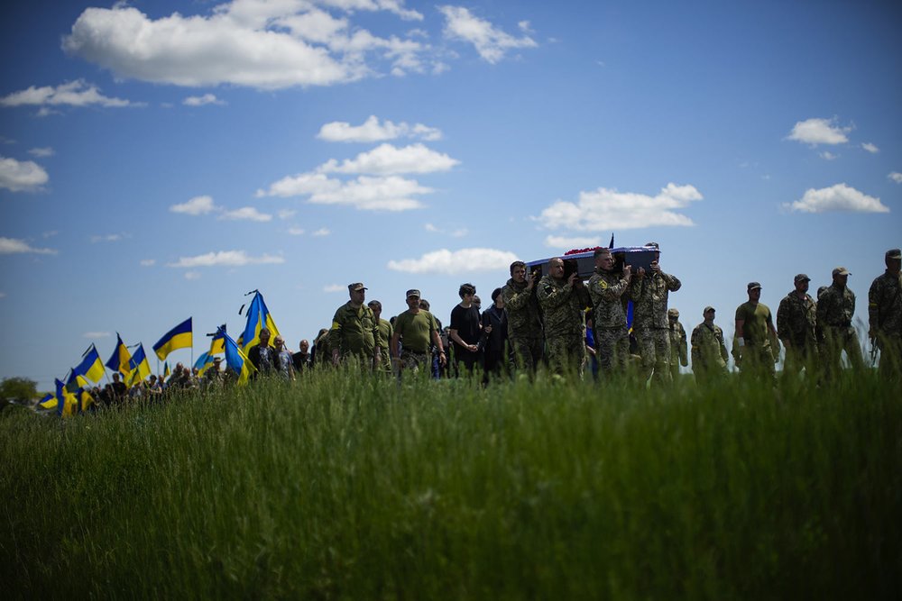  Ukrainian soldiers carry the coffin of Volodymyr Losev, 38, during his funeral in Zorya Truda in the Odesa region of Ukraine, Monday, May 16, 2022. The 38-year-old Ukrainian volunteer soldier was killed May 7 when the military vehicle he was driving