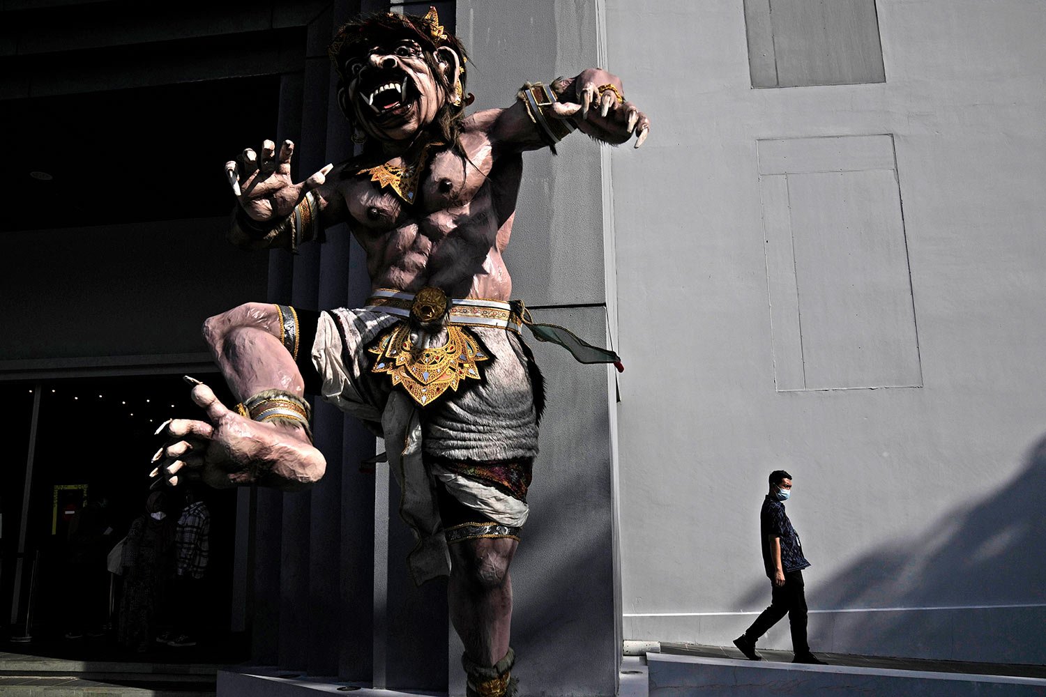  A man walks past a giant traditional Balinese effigy called 'ogoh-ogoh' at Garuda Wisnu Kencana Cultural Park which is prepared to be used as one of the venues of the G20 leaders summit, in Bali, Indonesia, Wednesday, May 25, 2022. (AP Photo/Dita Al