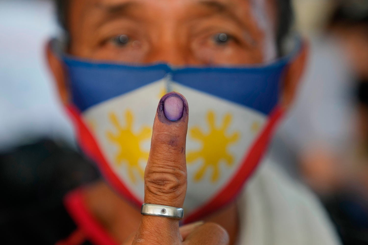  Raul Bragais, 64, shows the ink on his finger to mark that he has finished voting during the opening of elections on Monday, May 9, 2022 in Quezon City, Philippines. (AP Photo/Aaron Favila) 