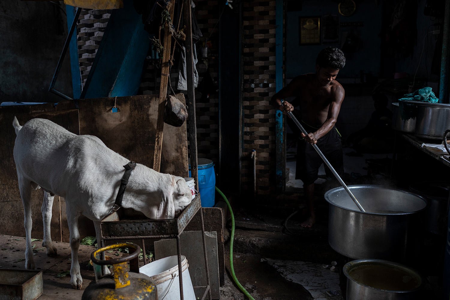  A man cooks at a kitchen located at a slum in Dharavi, Mumbai, India, Thursday, May 19, 2022. (AP Photo/Rafiq Maqbool) 