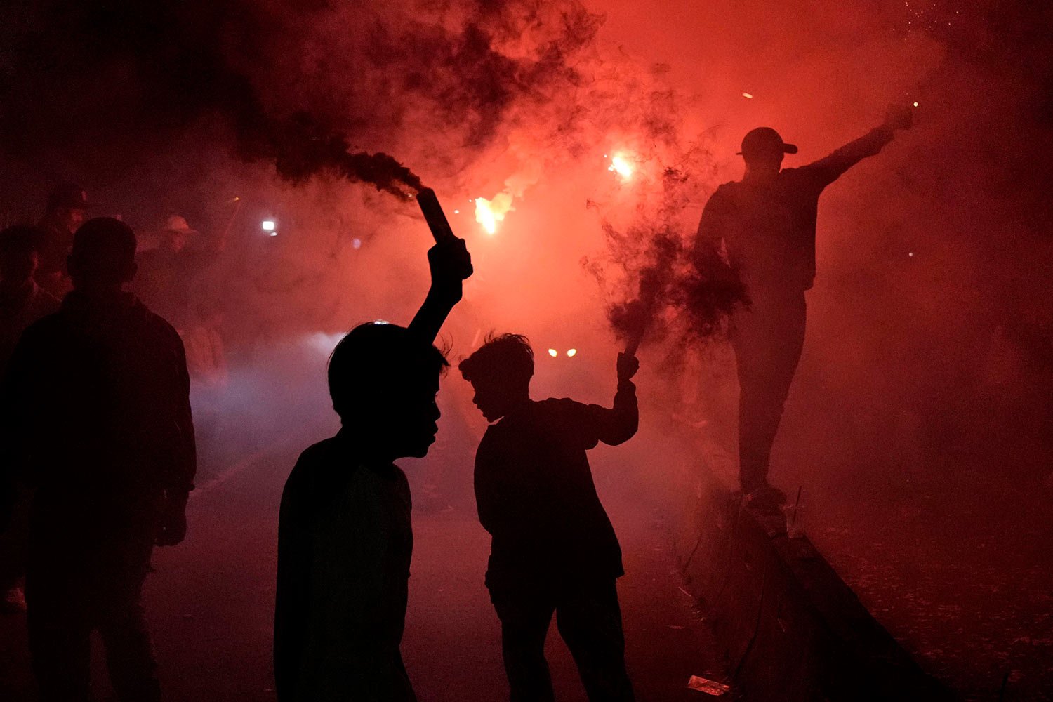  People light flares as they celebrate the eve of Eid al-Fitr, the holiday marking the end of the holy fasting month of Ramadan, on a street in Jakarta, Indonesia, Sunday, May 1, 2022. (AP Photo/Dita Alangkara) 