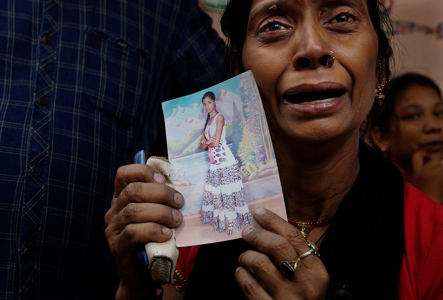  A woman shows a photograph of her daughter Sonam, 20, who was killed in a fire, outside a hospital mortuary in New Delhi, Saturday, May 14, 2022.  (AP Photo/Manish Swarup) 