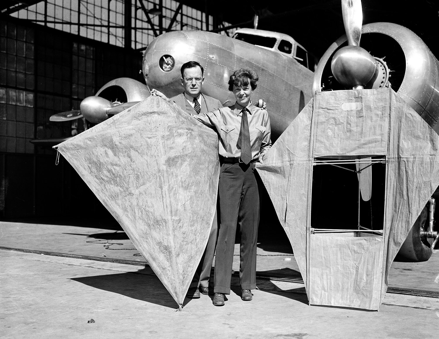  Amelia Earhart and her husband George Palmer Putnam display two kites as they stand in front of Earhart's twin-engine Lockheed Electra in Oakland, Calif., on March 6, 1937, ten days prior to her projected flight around the world. Earhart plans to fl
