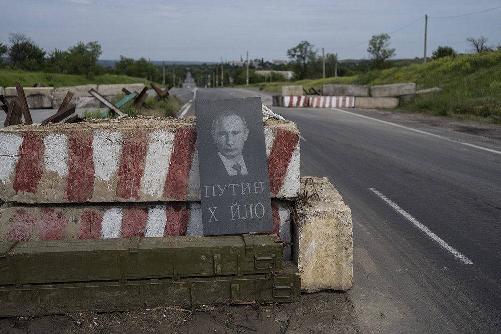  A tombstone with the picture of Russian President Vladimir Putin and a derogatory epithet sits at a checkpoint in the Donetsk oblast region of eastern Ukraine, Sunday, June 5, 2022. The text reads "Putin dickhead." (AP Photo/Bernat Armangue) 