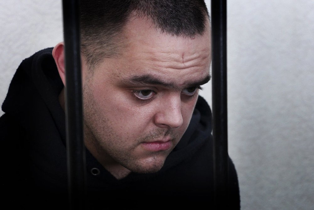  British citizen Aiden Aslin stands behind bars in a courtroom in Donetsk, in the territory which is under the control of the pro-Russian Government of the Donetsk People's Republic in eastern Ukraine, Thursday, June 9, 2022. Aslin is one of two Brit