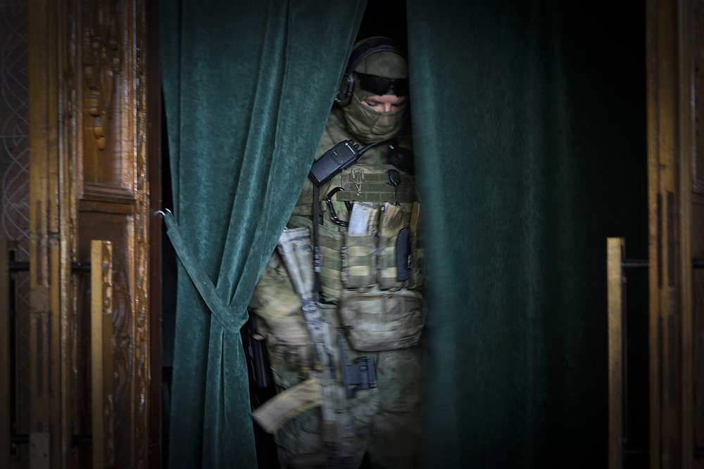  A Russian soldier steps through a curtained opening at the Philharmonic Chamber in Mariupol, in the territory which is under the control of the Government of the Donetsk People's Republic, in eastern Ukraine, Sunday, June 12, 2022. This photo was ta