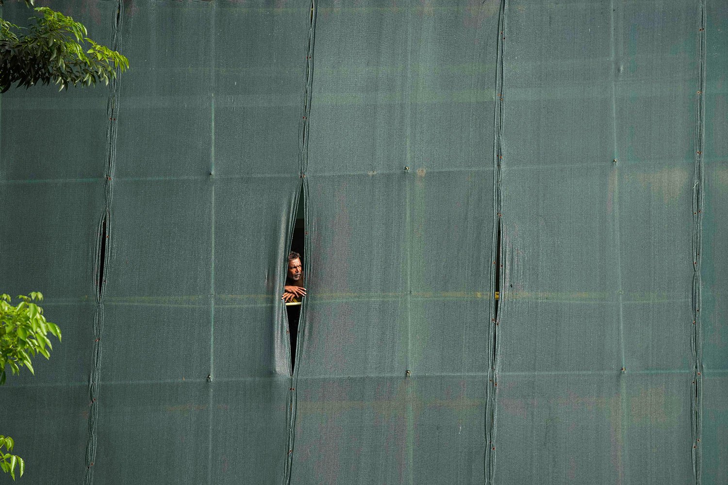  A man watches from a work site as students march demanding President Gotabaya Rajapaksa resign over the economic crisis in Colombo, Sri Lanka, Monday, June 20, 2022. (AP Photo/Eranga Jayawardena) 