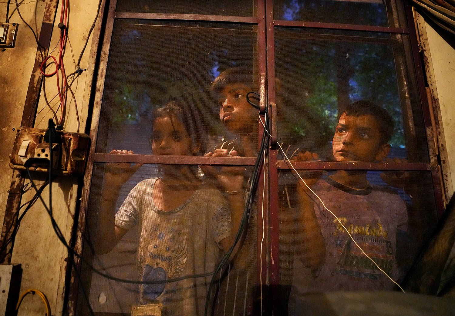 Kashmir's minority Hindu children look through a netted window at Purkhoo migrant camp on the outskirts of Jammu, India, June 11, 2022. (AP Photo/Channi Anand) 