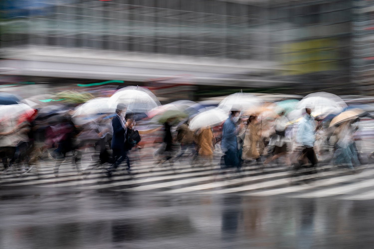  In this photo taken with a slow-shutter speed exposure, morning commuters walk across an intersection in rain Monday, June 6, 2022, in Tokyo. (AP Photo/Kiichiro Sato) 