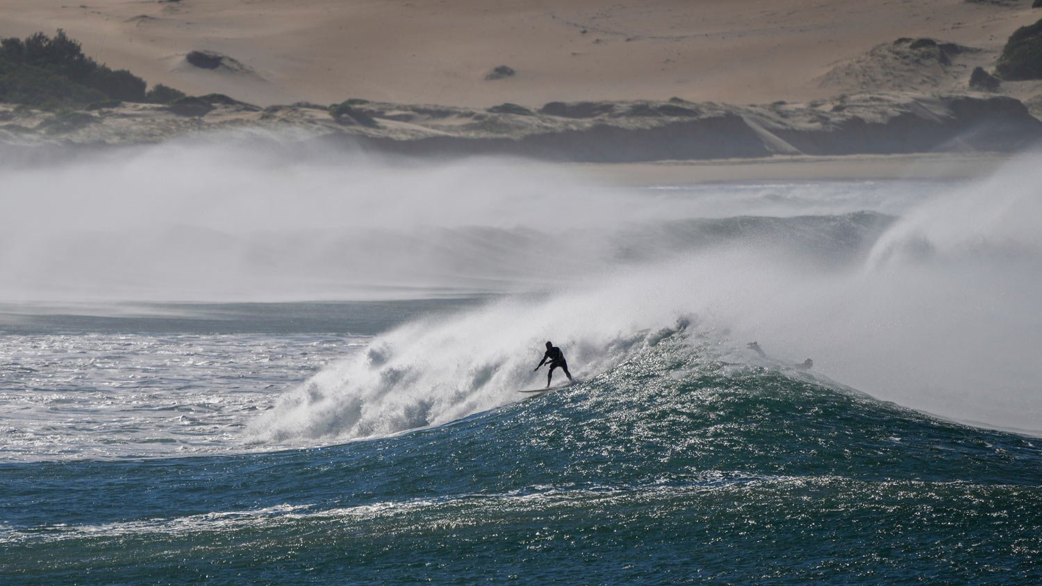  A surfer rides a wave at One Mile Beach at Port Stephens, Australia, Sunday, June 12, 2022. (AP Photo/Mark Baker) 