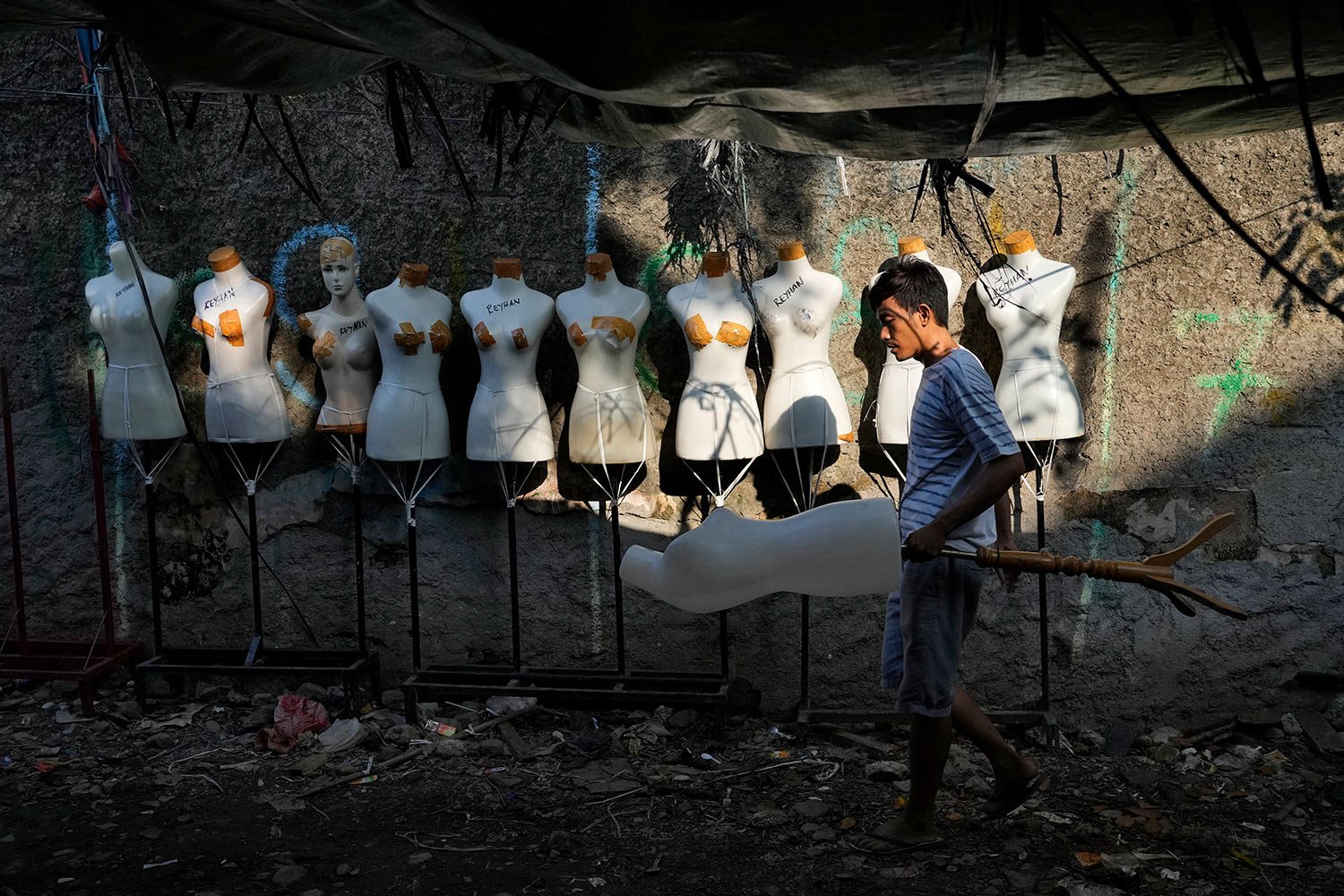  A worker collects mannequins torsos at the Tanah Abang textile market in Jakarta, Indonesia, Monday, June 20, 2022. (AP Photo/Tatan Syuflana) 