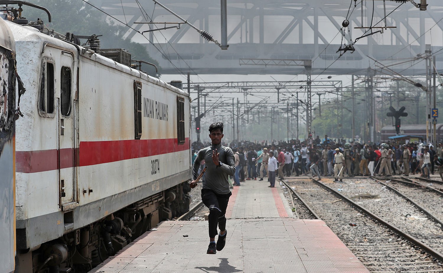  A protester runs after hearing gun shots at Secunderabad railroad station in Hyderabad, India, Friday, June 17, 2022. (AP Photo/Mahesh Kumar A) 
