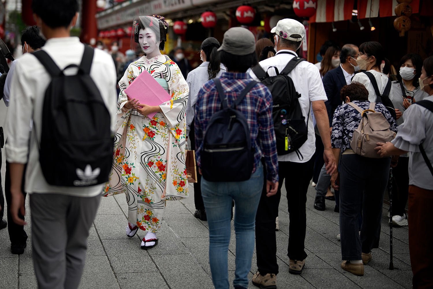  A Geisha woman in traditional Japanese "kimono" walks along a shopping street at the Asakusa district Friday, June 10, 2022, in Tokyo. (AP Photo/Eugene Hoshiko) 