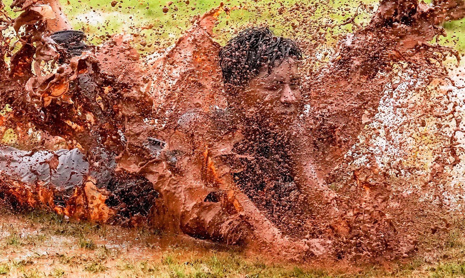  A boy dives in a puddle of muddy water as he enjoys the rains in Mumbai, India, Monday, June 27, 2022. (AP Photo/Rajanish Kakade) 