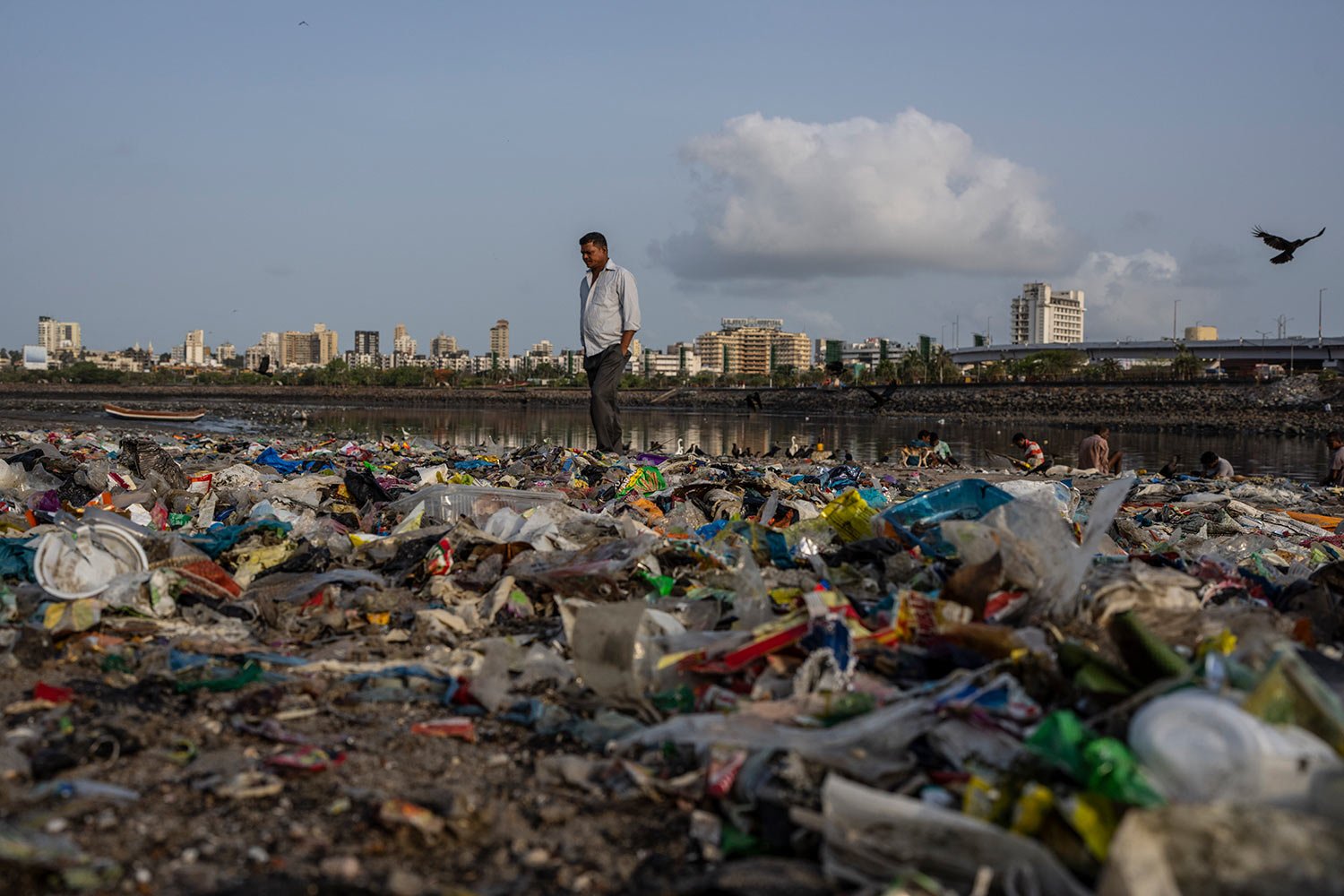  A man walks past plastic and other garbage littered on the shores of the Arabian Sea on World Environment Day, in Mumbai, India, Sunday, June 5, 2022. (AP Photo/Rafiq Maqbool) 