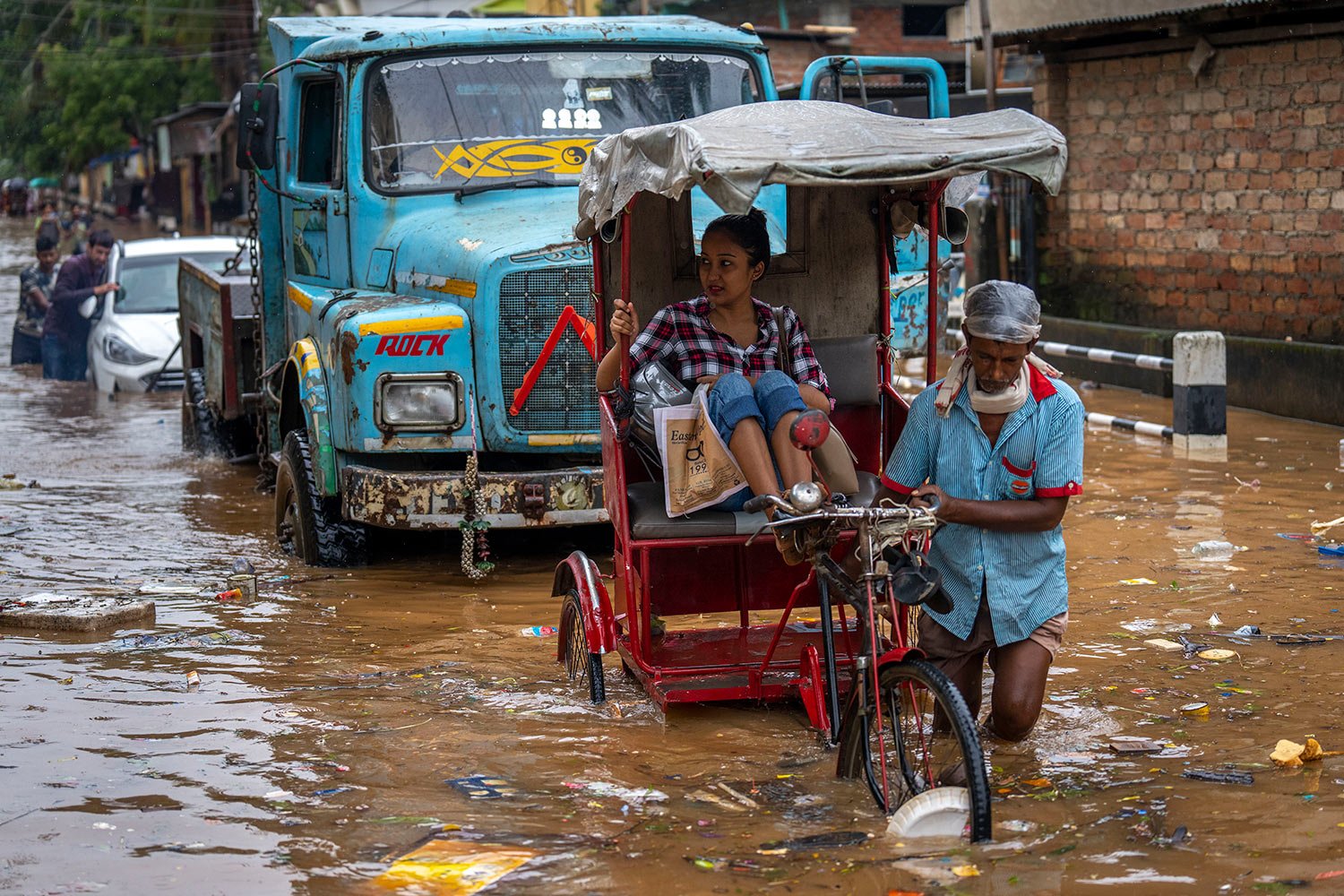  A rickshaw driver ferries a passenger past a waterlogged street after continuous rainfall in Gauhati, India, Wednesday, June 15, 2022. (AP Photo/Anupam Nath) 