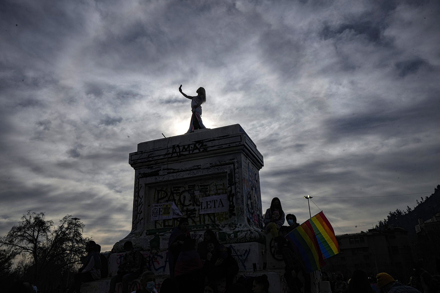  A transgender poses for a selfie on the pedestal of a monument in the annual Pride march in Santiago, Chile, Saturday, June 25, 2022. (AP Photo/Esteban Felix) 