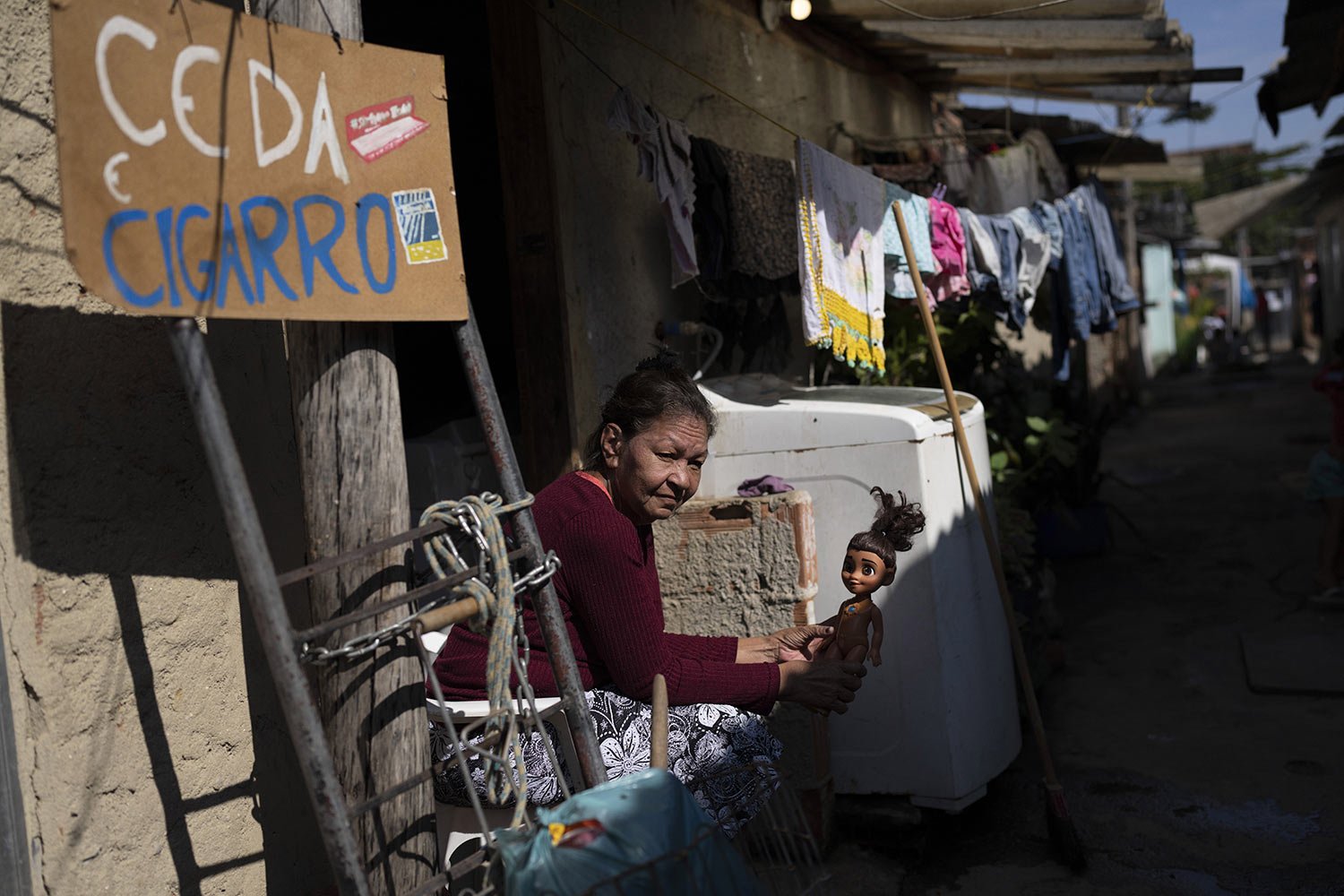  Maria, who works as a seamstress, sells handmade crochet rags as she sits outside her home, alongside others built on squatted land in Rio de Janeiro, Brazil, Monday, June 20, 2022. (AP Photo/Silvia Izquierdo) 