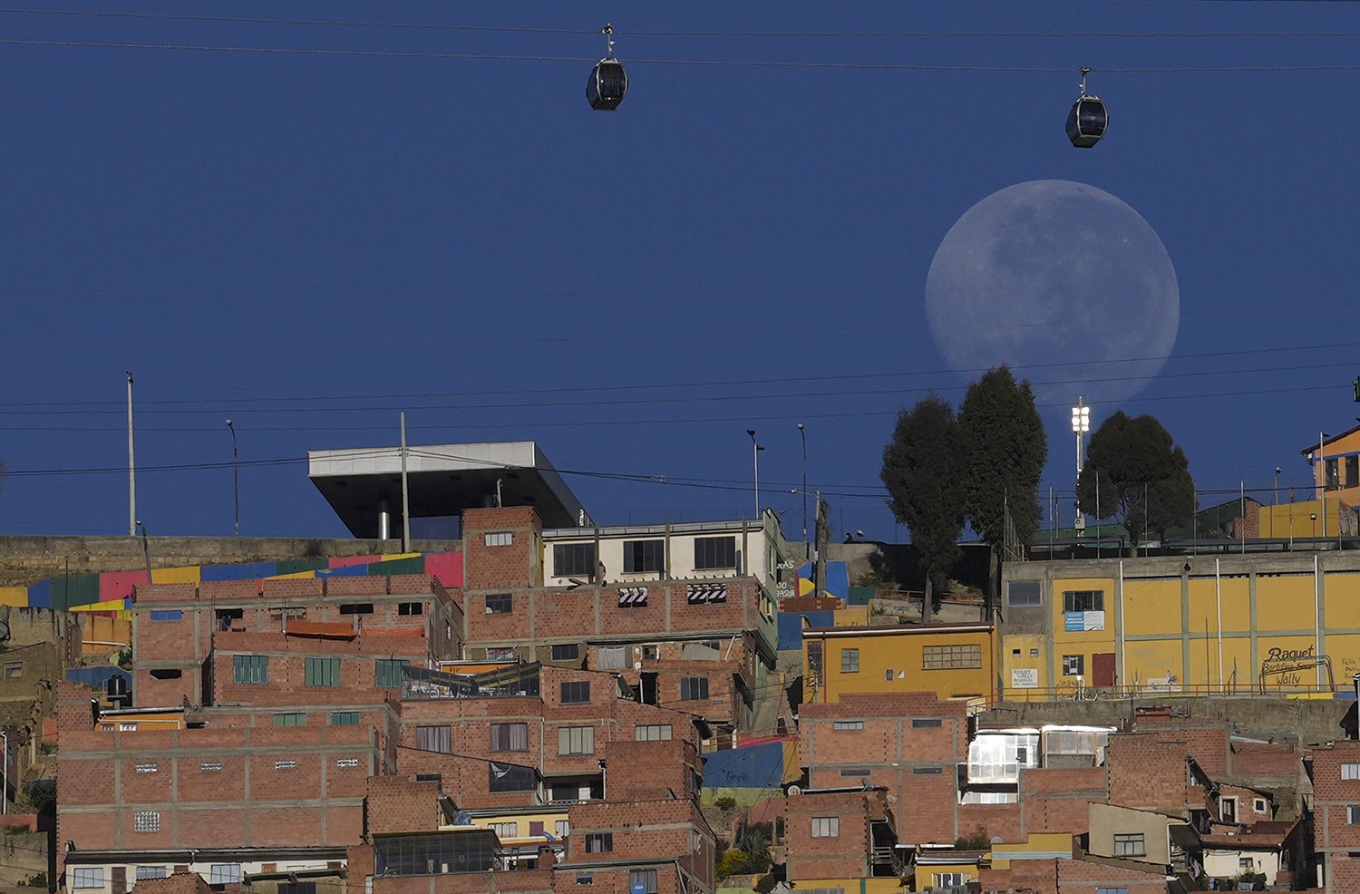  Cable cars that interconnect the city of El Alto and La Paz, Bolivia, backdropped by the strawberry moon, ride high above El Alto, Bolivia, Thursday, June 16, 2022. (AP Photo/Juan Karita) 