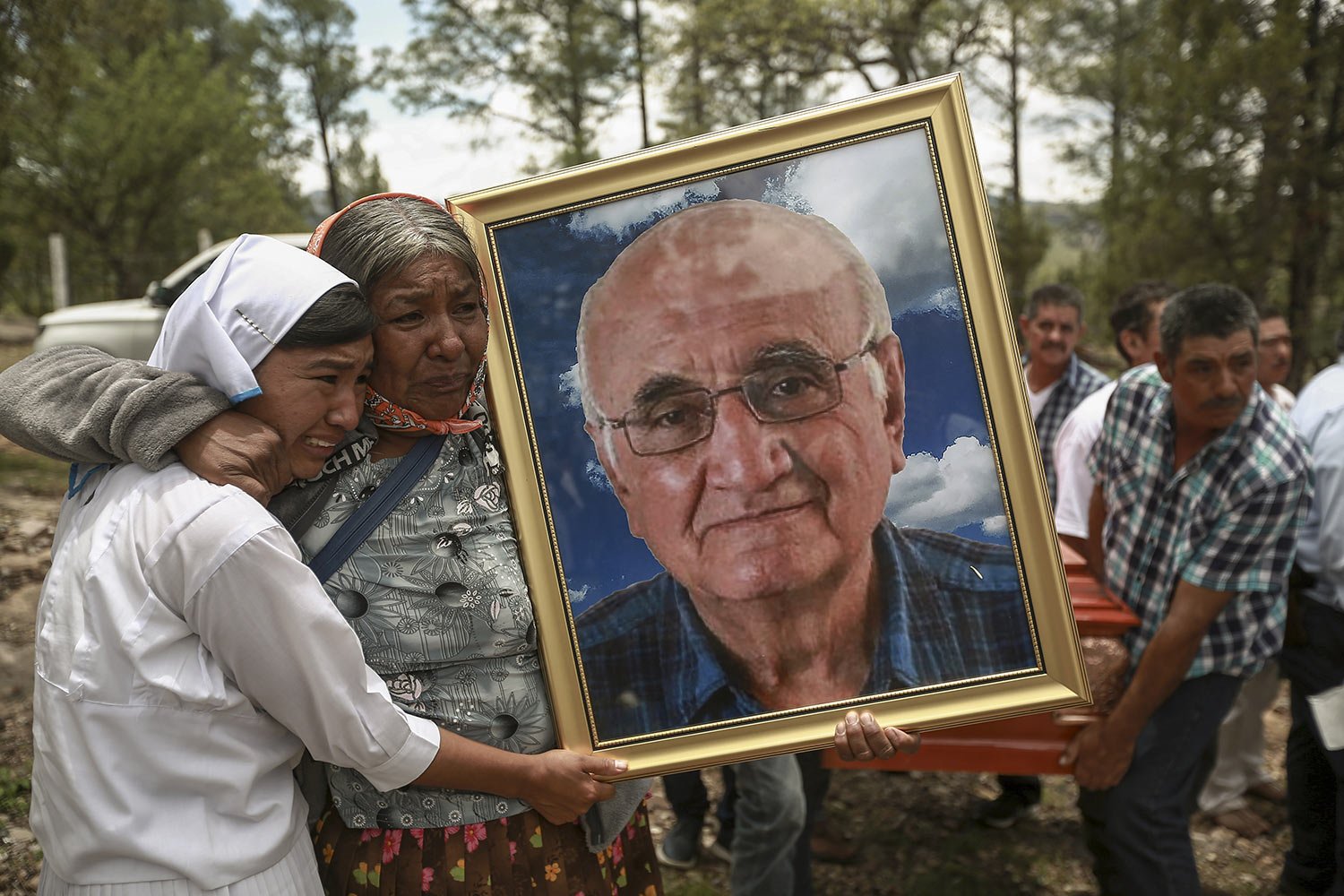  Women hold a portrait of Jesuit priest Javier Campos Morales as the funeral procession of Morales and fellow priest Joaquin Cesar Mora Salazar arrives to Cerocahui, Chihuahua state, Mexico, Sunday, June 26, 2022. The two elderly priests killed in th