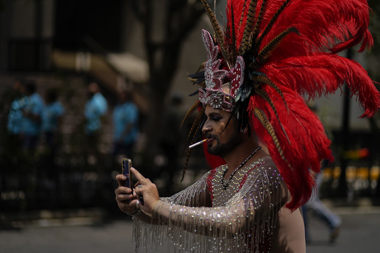  Wearing an Aztec headdress and smoking a cigarette, a participant poses for a selfie while taking part in the annual Pride march in Mexico City, Saturday, June 25, 2022. (AP Photo/Eduardo Verdugo) 