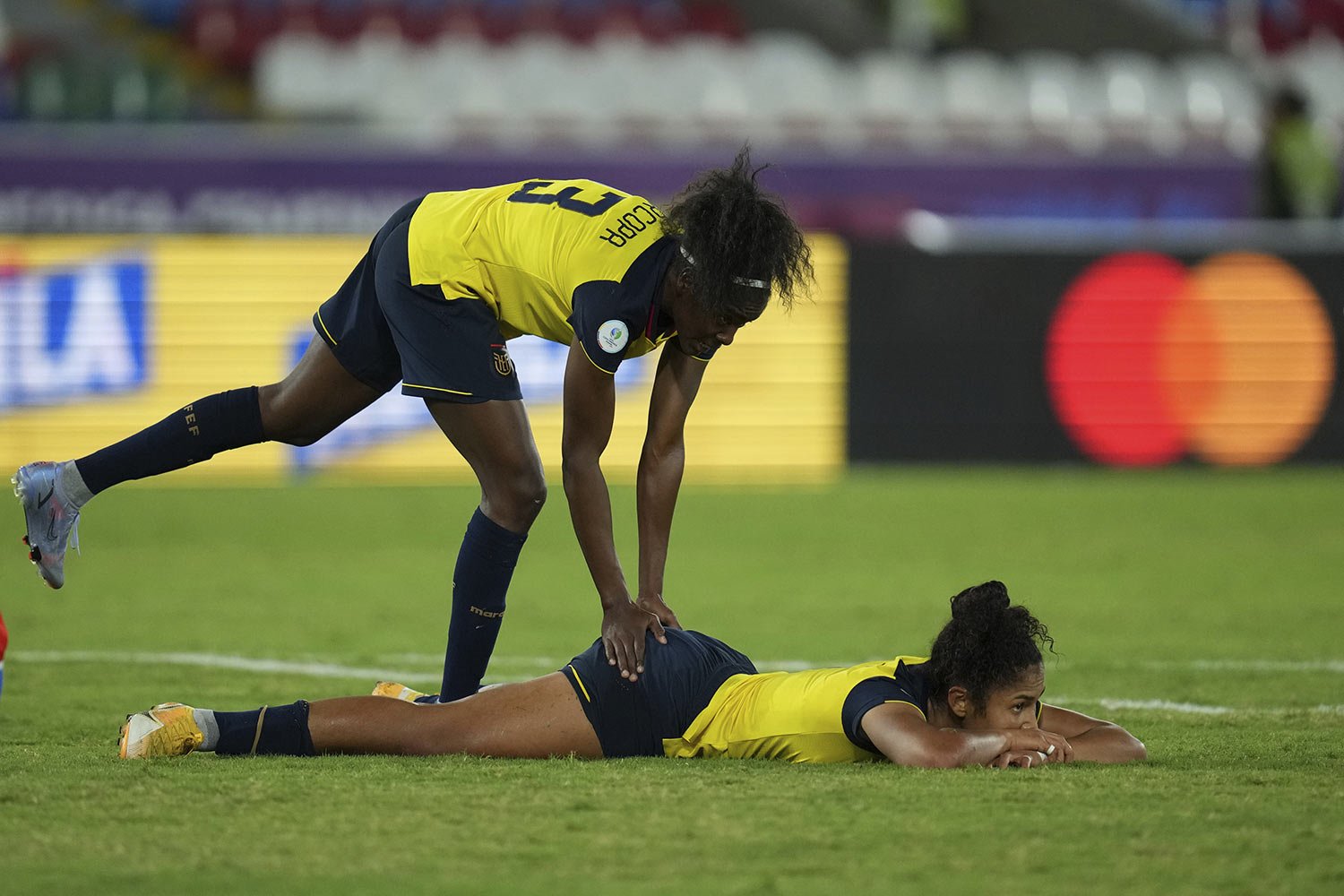  Ecuador's Ariana Lomas, top, comforts her teammate Nayely Bolaños after missing a chance to score against Chile during a Women's Copa America soccer match in Cali, Colombia, Thursday, July 14, 2022. (AP Photo/Dolores Ochoa) 