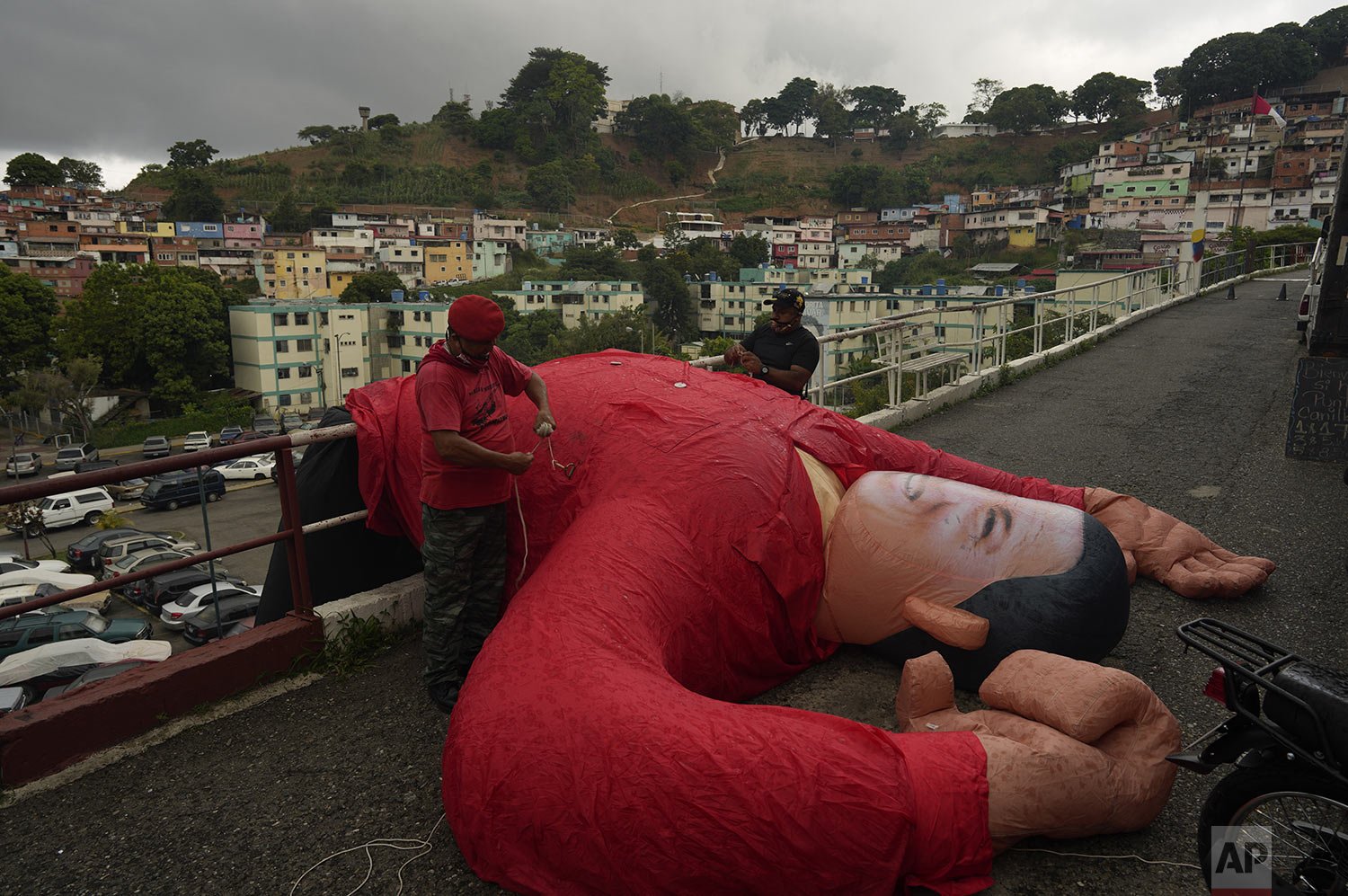 Supporters of Venezuela's late President Hugo Chavez bring down an inflatable doll of him during a commemoration of what would have been the leader's 68th birthday, in the 23 de Enero neighborhood of Caracas, Venezuela, Thursday, July 28, 2022. (AP