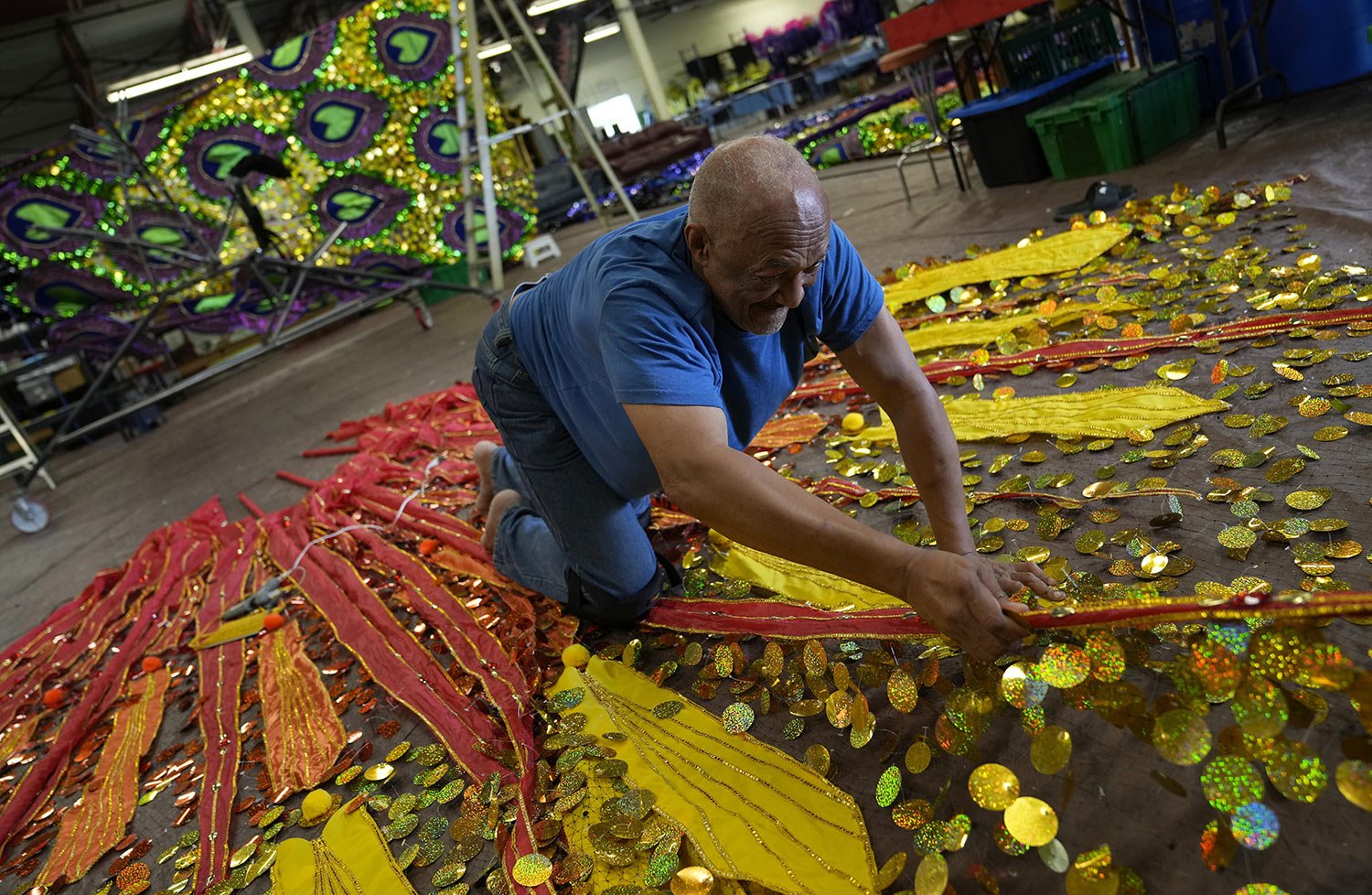  Kenney Coombs, a retired government employee, works on his latest design, titled Queens & Goddesses, at the Carnival Nationz’s Mas Camp in Toronto, Canada, Sunday, July 24, 2022. (AP Photo/Kamran Jebreili) 