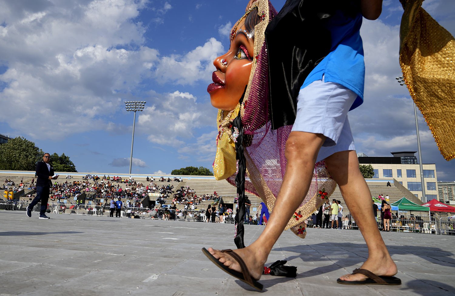  A person arrives carrying Carnival costumes in preparation for the King and Queen Showcase at Lamport Stadium in Toronto, Canada, Thursday, July 28, 2022. (AP Photo/Kamran Jebreili) 