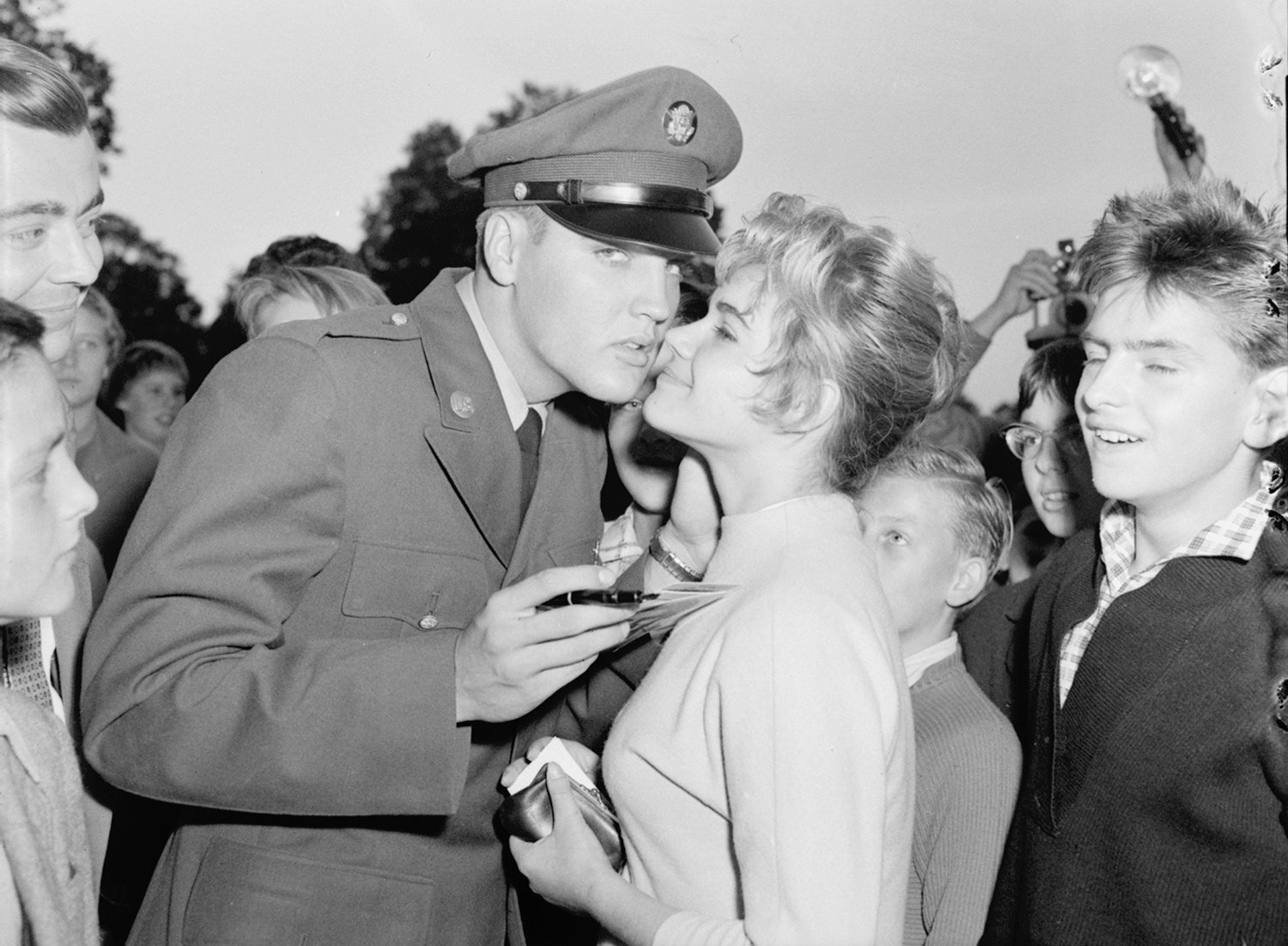  Seventeen-year-old Margit Burgin, of Frankfurt, Germany, is kissed by Pvt. Elvis Presley at the request of photographers in Bad Homburg, West Germany, Oct. 8, 1958. Presley, assigned to the Third Armored Division at Friedberg, was at liberty on a we